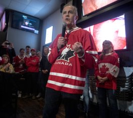 Picture of Canadian PM Mark Carney speaking, while wearing a Team Canada hockey sweater