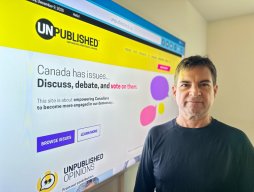 James O'Grady's Mission to Rebuild Trust in a Fragmented Media Era: Inside the Vision Behind Unpublished Media James O'Grady standing in front of big computer screen of his company's website: Unpublished.ca